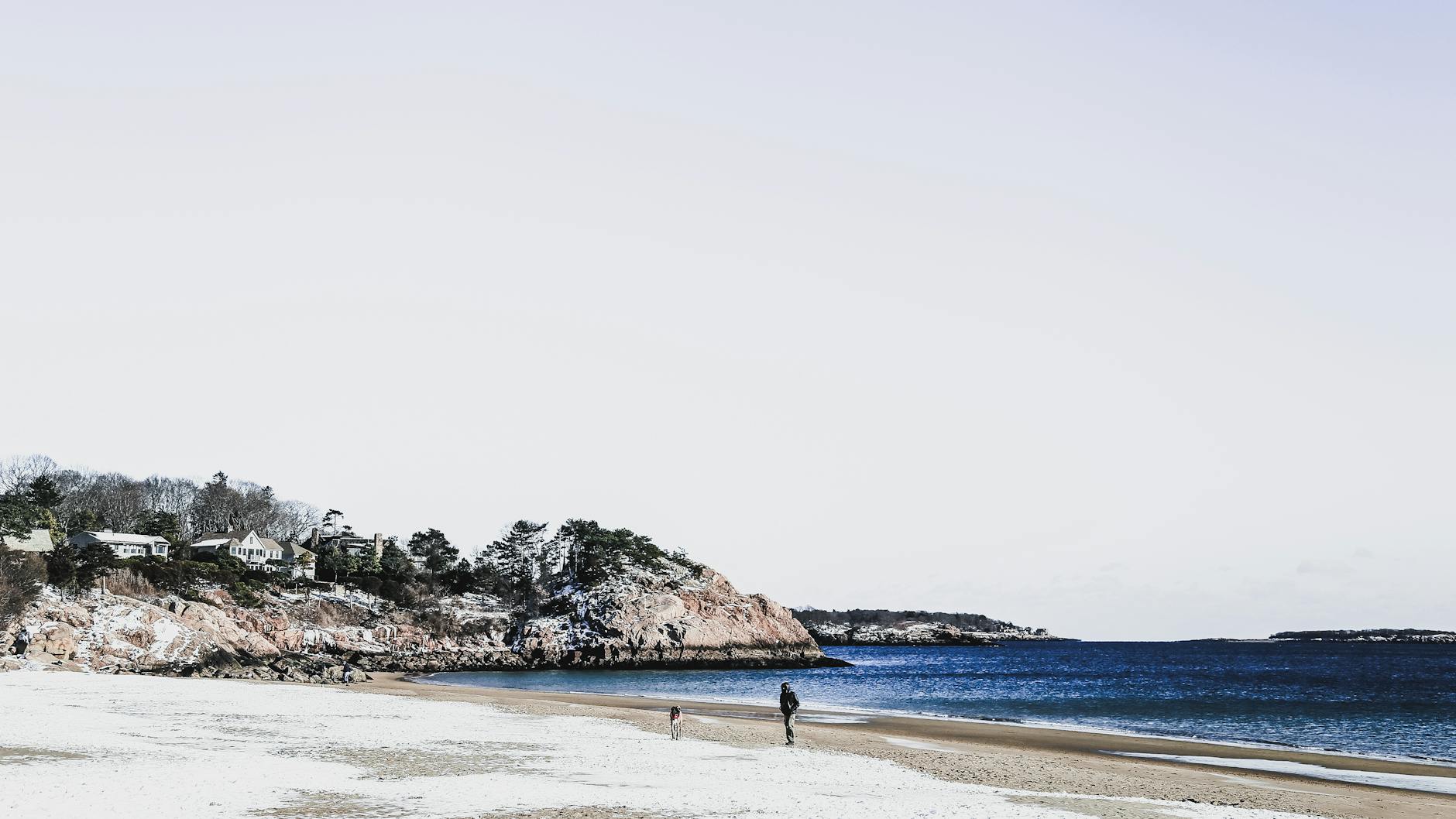 Zimowa, ośnieżona plaża nad morzem z błękitną wodą