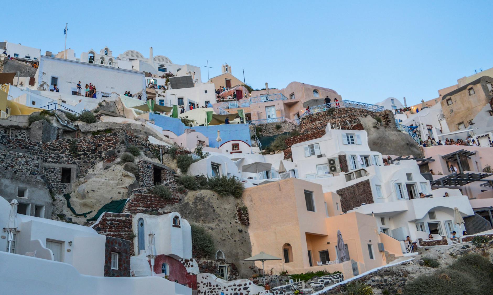 Białe domy na wzgórzu w Santorini pod błękitnym niebem