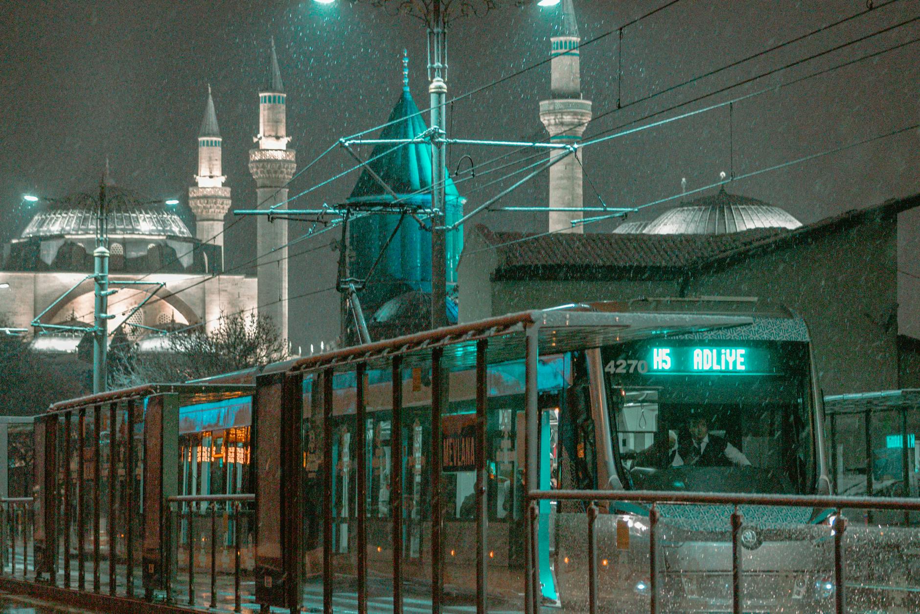 Nocny tramwaj na śniegu w Konyi na tle muzeum Mevlany