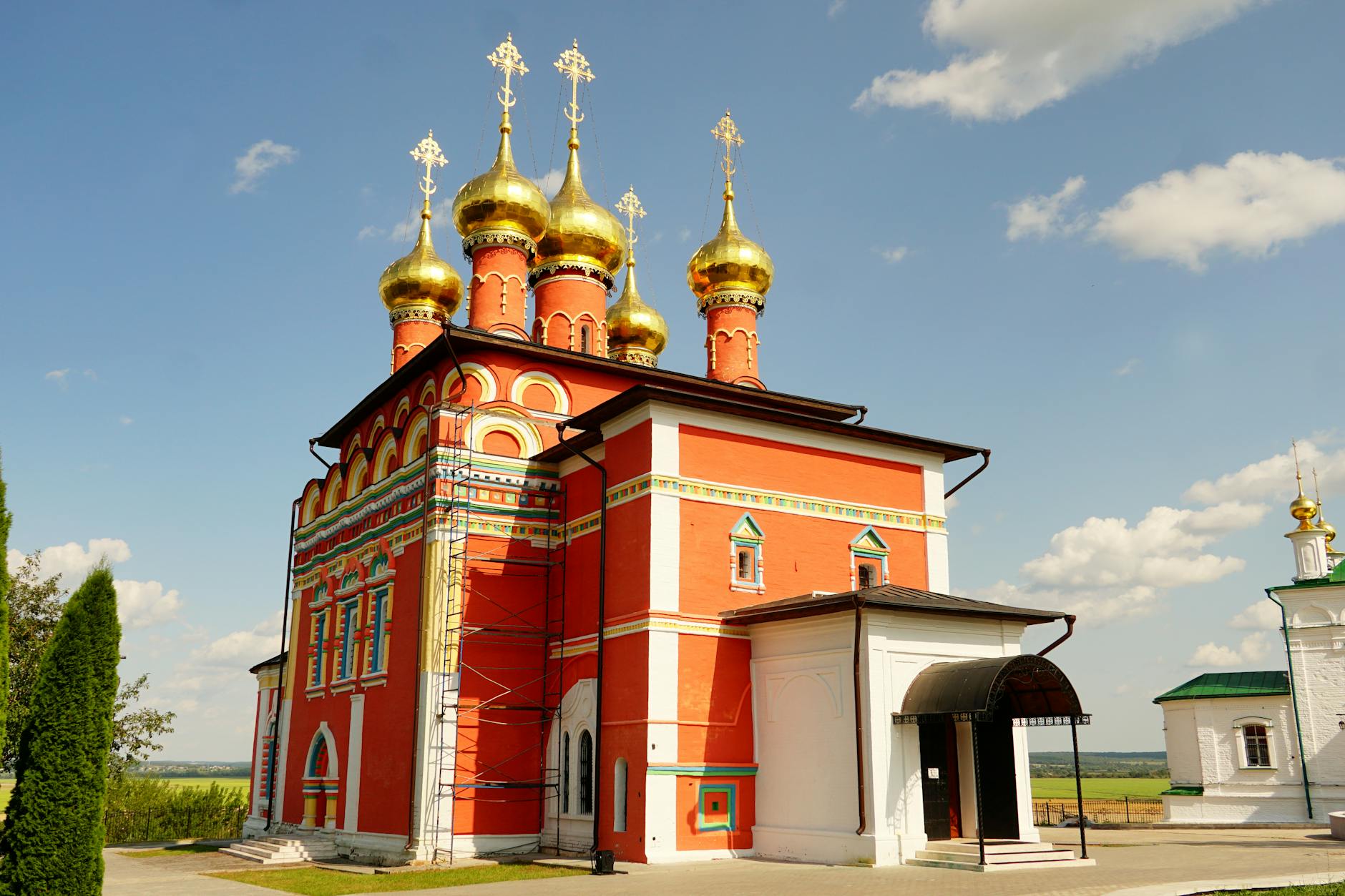 Kolorowa cerkiew prawosławna z złotymi kopułami na tle błękitnego nieba Kolorowa cerkiew prawosławna z złotymi kopułami na tle błękitnego nieba
