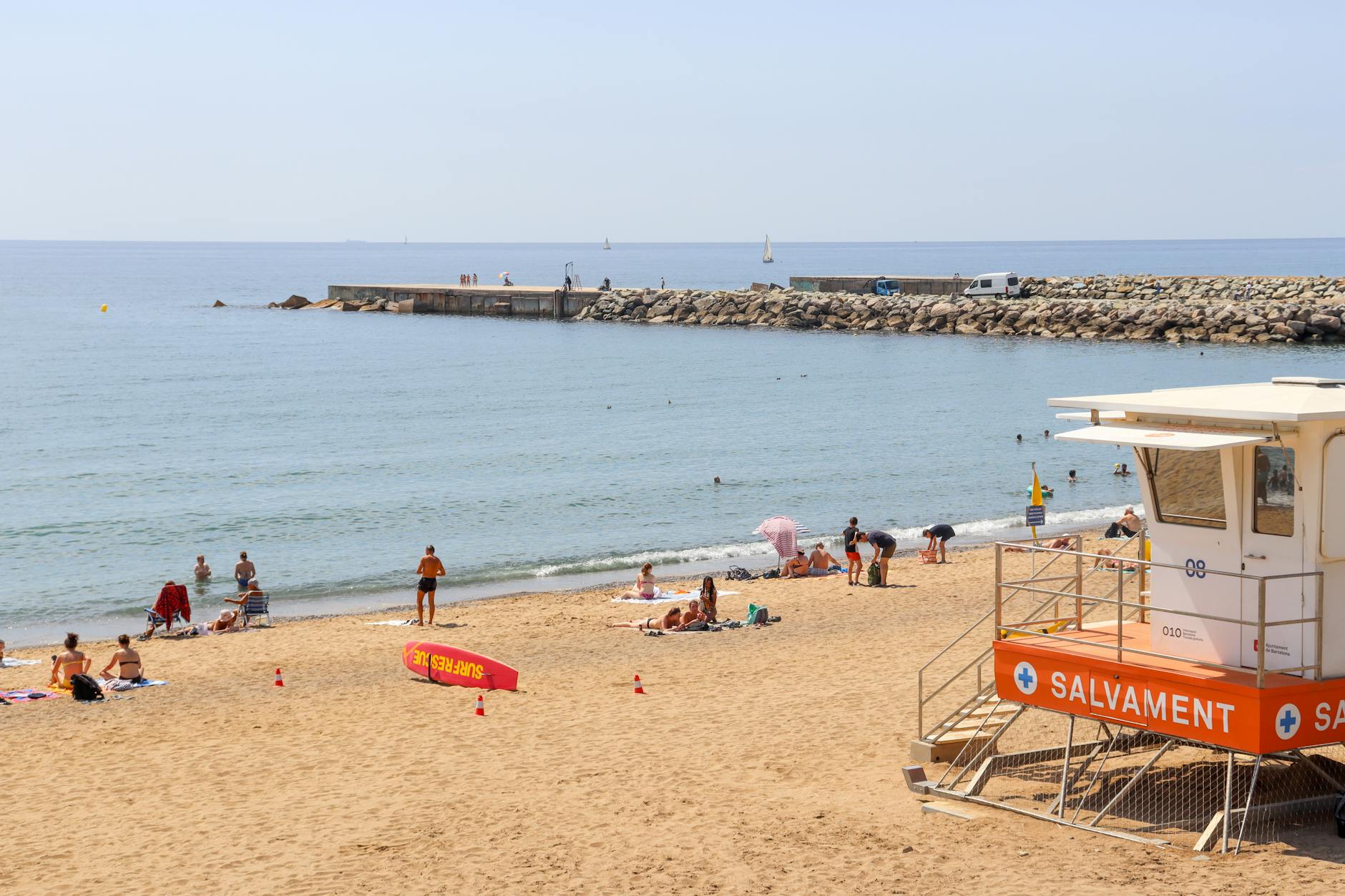 Tłoczna plaża Barceloneta w Barcelonie z wieżą ratownika