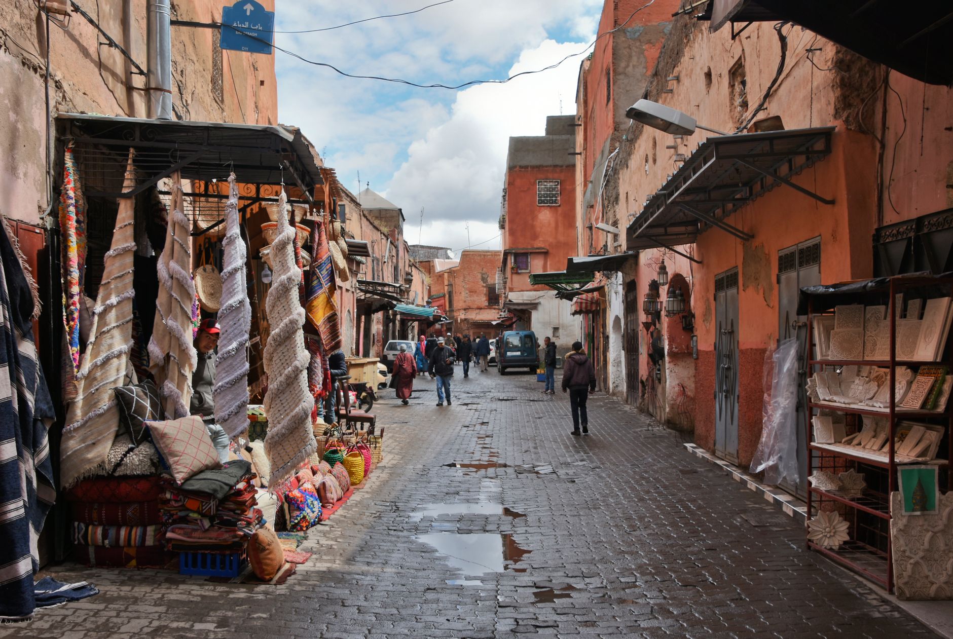 Tętniący życiem targ w Marrakeszu z kolorowymi tkaninami i zabudową